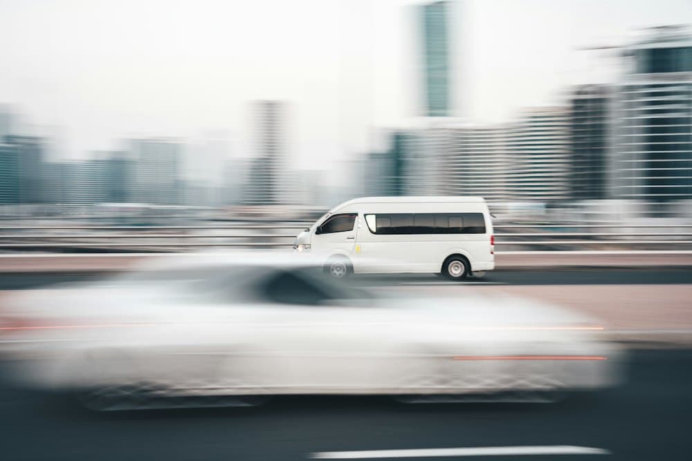 White high-roof passenger van crossing a bridge